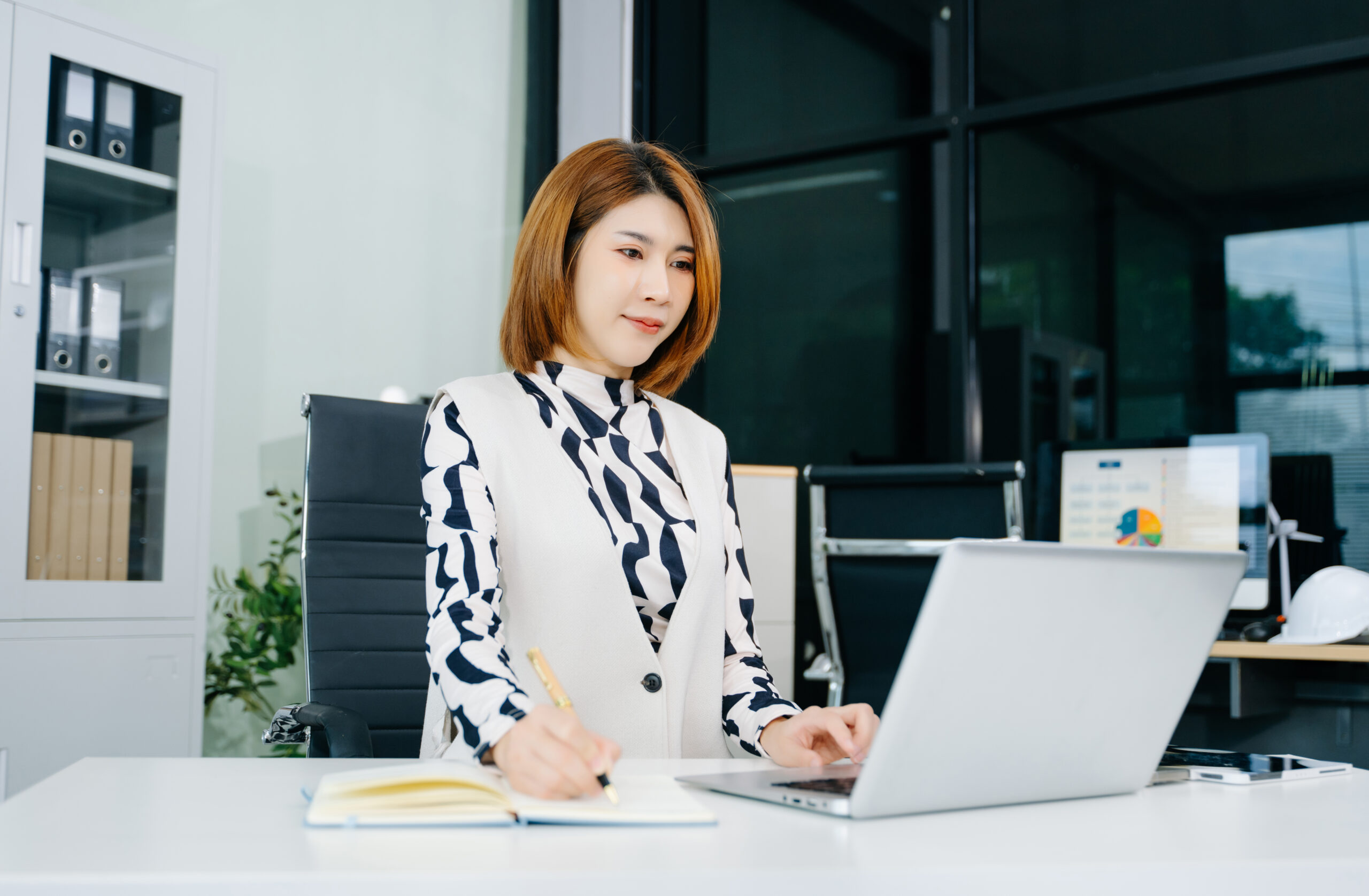 Business woman using tablet and laptop for doing math finance on an office desk, tax, report, accounting, statistics, and analytical research concept in office